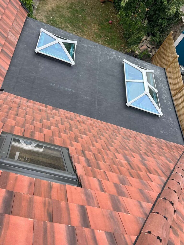 This is a photo taken from the roof ridge looking down a tiled pitched roof on to a flat roof. Works carried out by TRP Roofing Selby